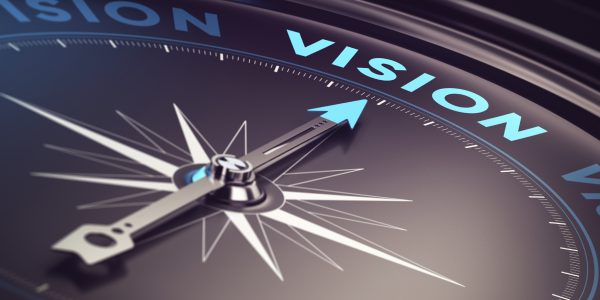 Compass with needle pointing the word vision with blur effect plus blue and black tones. Conceptual image for immustration of company or business anticipation or strategy